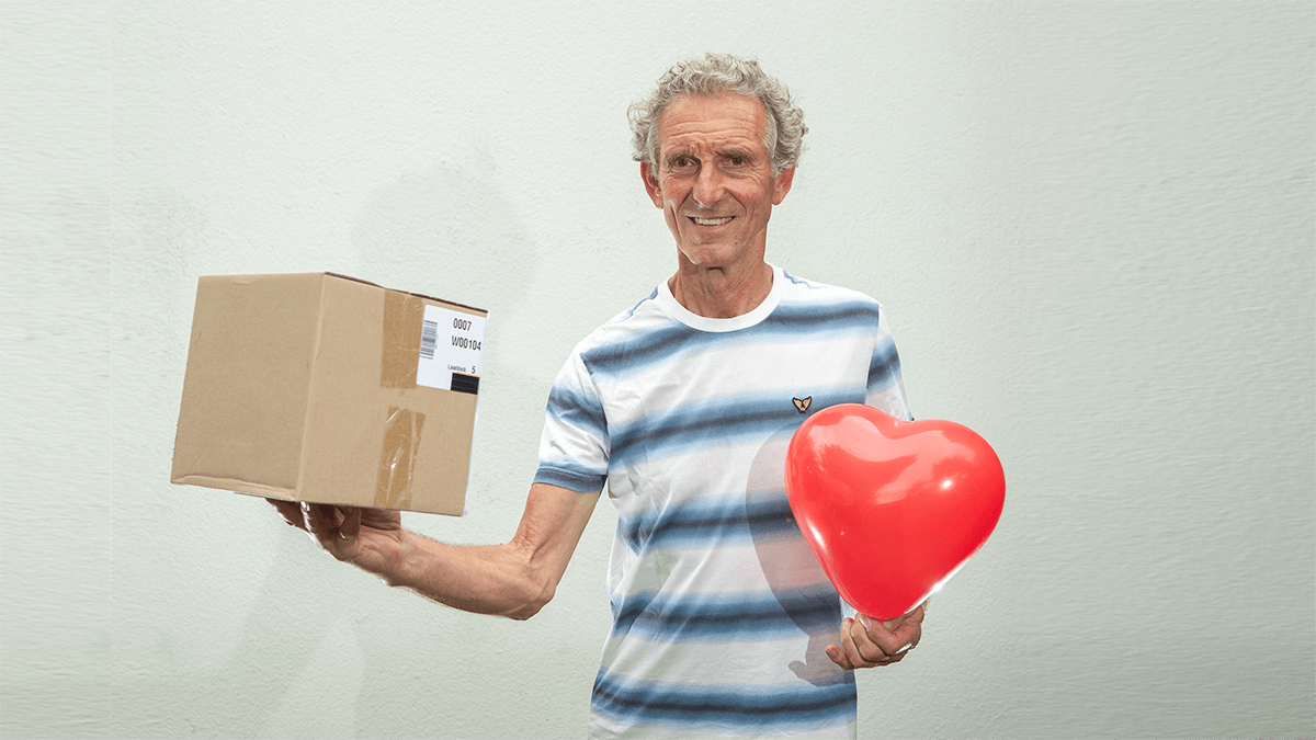 Foto van coach Cor van Ruijven van CvR VISIE met een doos en een hartjesballon in zijn handen. De foto hoort bij Enneagram Type 2. De Helper.